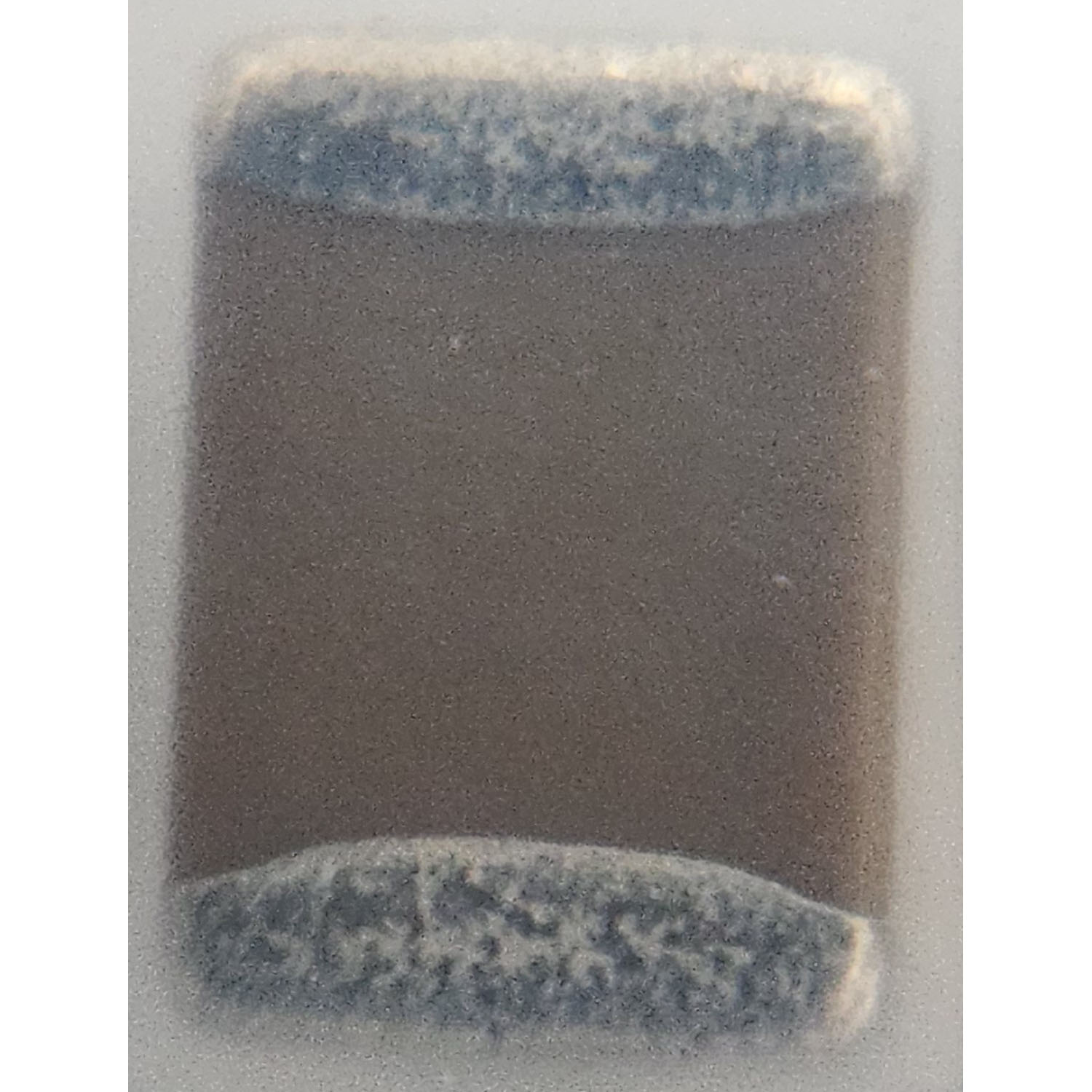 Motorola 2113918B09 high-voltage ceramic chip capacitor back view in protective packaging showing component body and end terminations